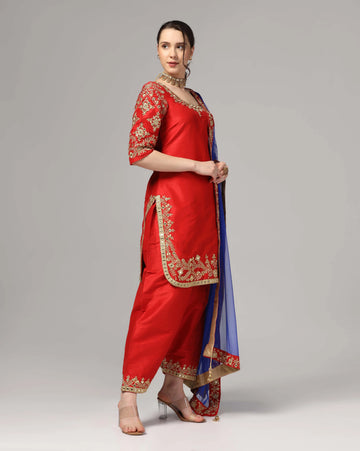 Red dupion silksuit with blue dupatta zari-thread & mirror work.